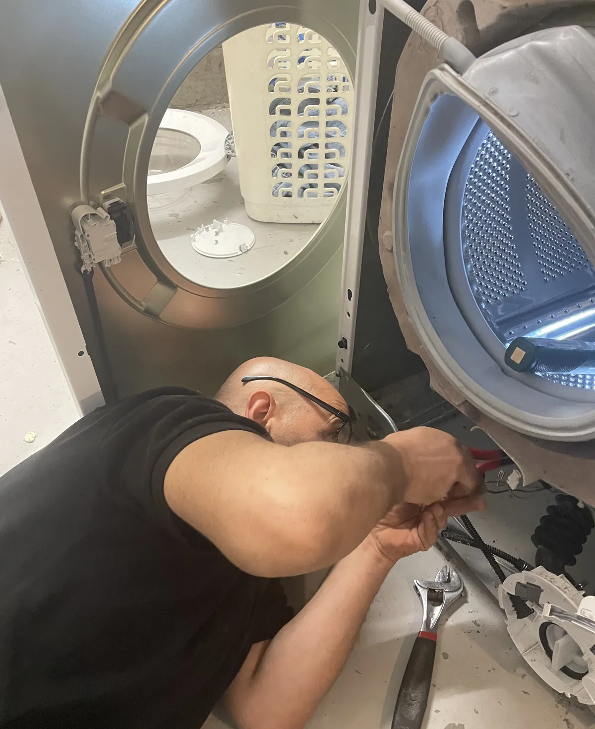Technieker van Repairdoctors verwijdert een vreemd voorwerp tussen de trommel en de kuip van een wasmachine