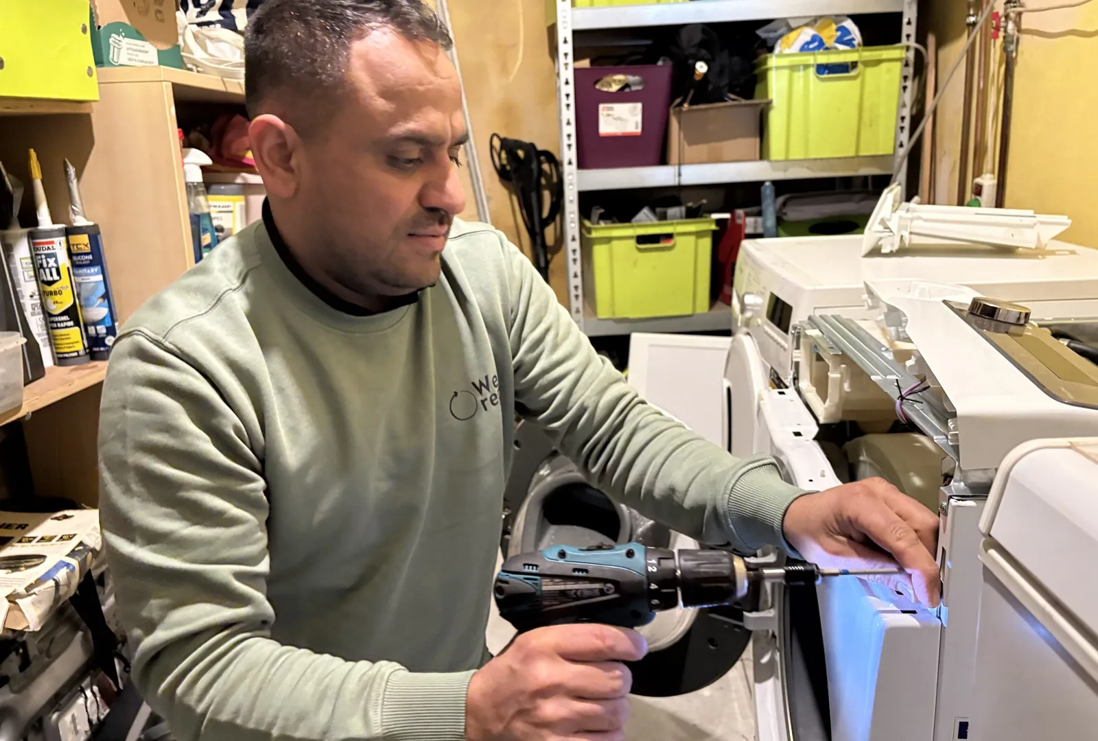 Technieker van Repairdoctors verwijdert vreemde voorwerpen die langs het pluizenfilter van een wasmachine waren geraakt